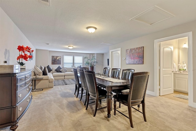 carpeted dining area with a textured ceiling