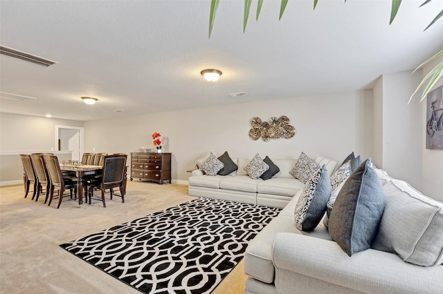 living room featuring light carpet and a textured ceiling