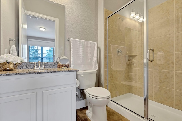 bathroom featuring tile patterned floors, vanity, toilet, and an enclosed shower