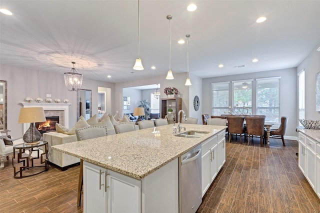 kitchen featuring a kitchen island with sink, white cabinets, and stainless steel dishwasher