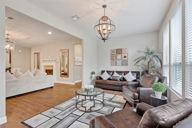 living room with a healthy amount of sunlight, light wood-type flooring, and an inviting chandelier