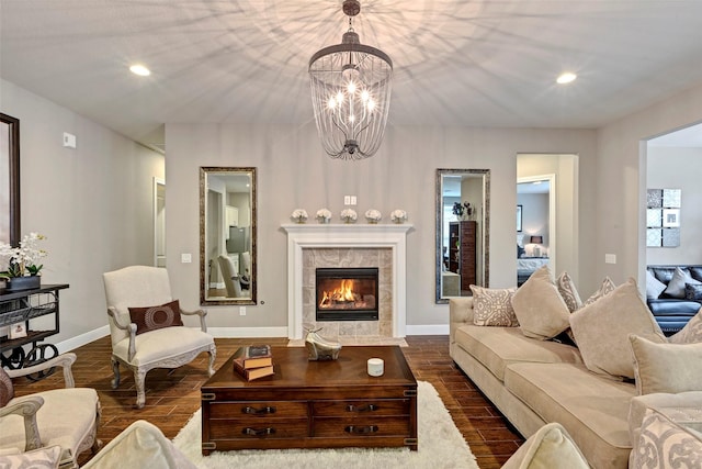 living room with a tile fireplace, a chandelier, and dark hardwood / wood-style floors