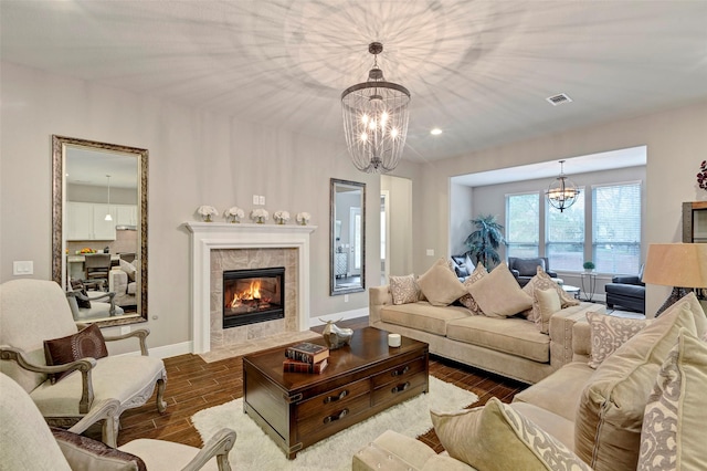 living room with a tile fireplace, hardwood / wood-style flooring, and an inviting chandelier