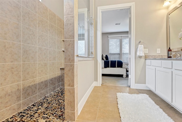 bathroom featuring tiled shower, vanity, and tile patterned floors