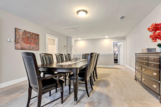 carpeted dining area featuring a textured ceiling