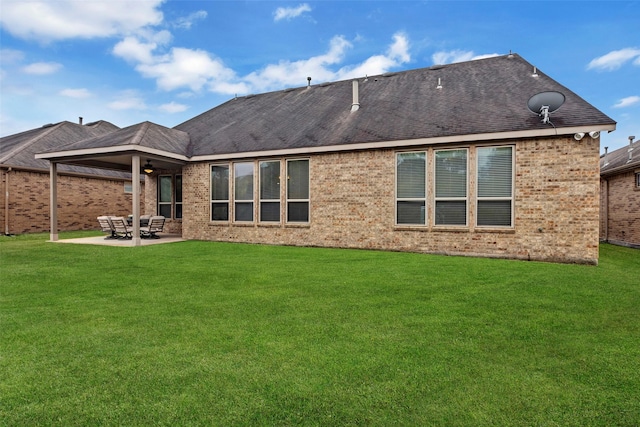 rear view of house with ceiling fan, a yard, and a patio