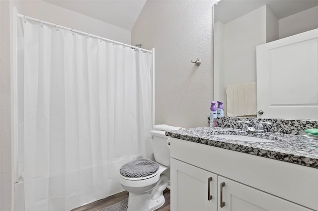 full bathroom featuring shower / bath combination with curtain, vanity, hardwood / wood-style floors, toilet, and lofted ceiling