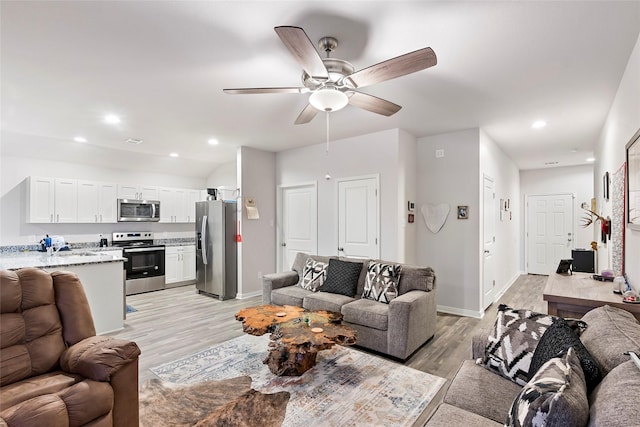 living room with light hardwood / wood-style floors and ceiling fan