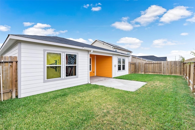 rear view of property featuring a patio area and a yard