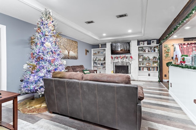 living room featuring a fireplace, wood-type flooring, and built in features