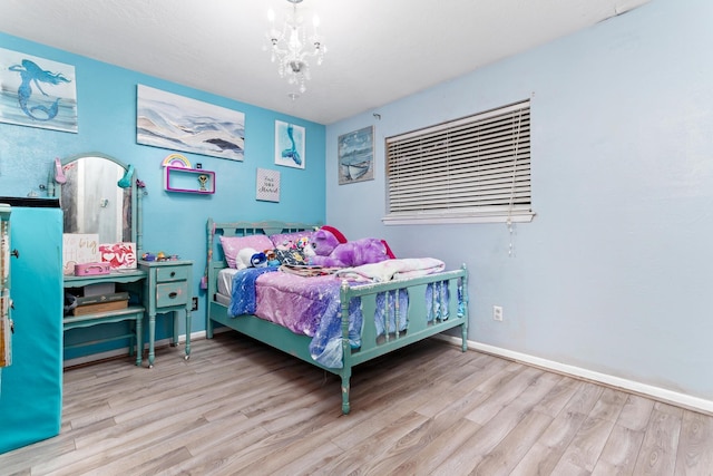 bedroom with an inviting chandelier and light hardwood / wood-style flooring