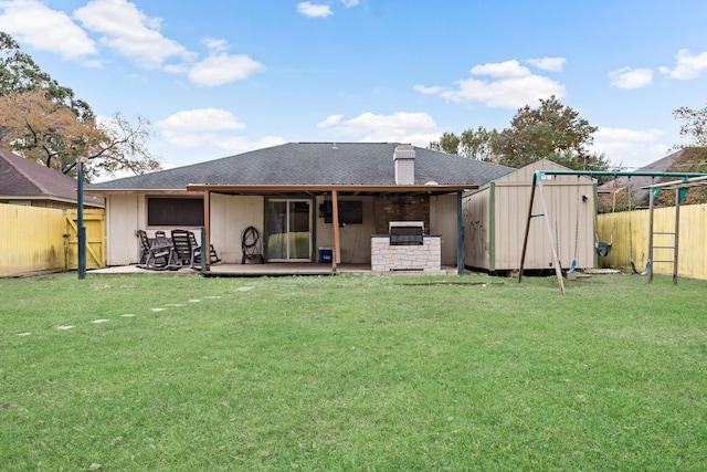 back of house with a lawn, a patio, and a shed