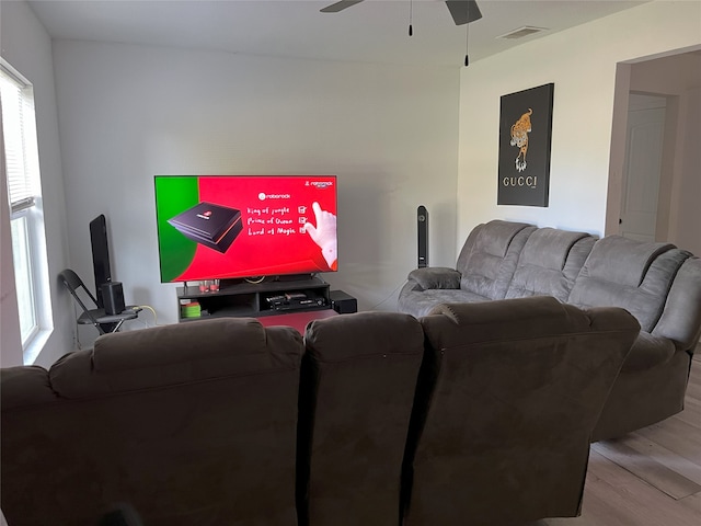 living room featuring a ceiling fan, visible vents, and light wood-style floors