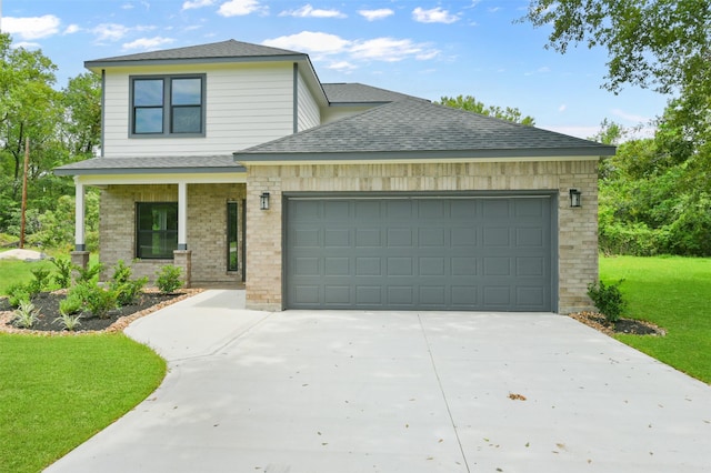 view of front of home with covered porch, a garage, and a front yard