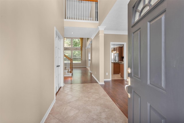 foyer entrance with light hardwood / wood-style floors and ornamental molding