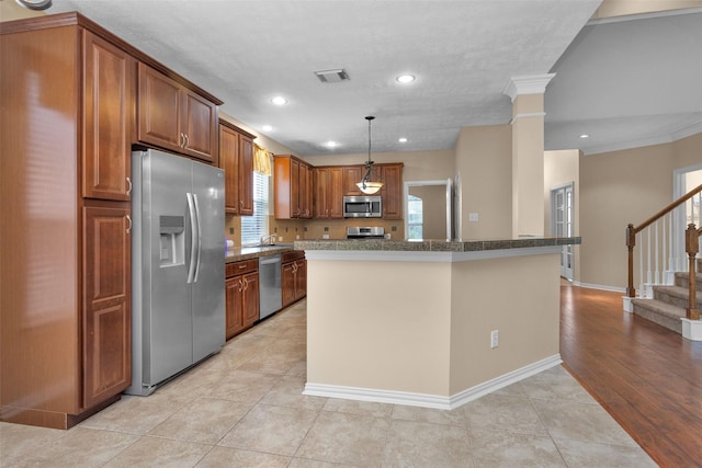 kitchen with stainless steel appliances, crown molding, light hardwood / wood-style flooring, a center island, and hanging light fixtures