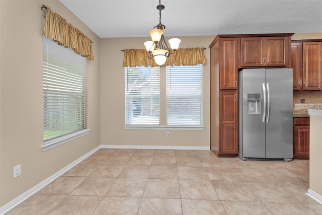 kitchen with stainless steel fridge, plenty of natural light, a notable chandelier, and light tile patterned flooring