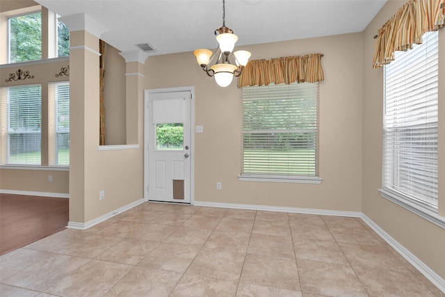 interior space with decorative columns, light tile patterned floors, and a chandelier