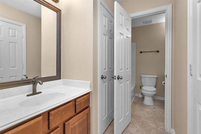 bathroom featuring tile patterned flooring, vanity, toilet, and a tub