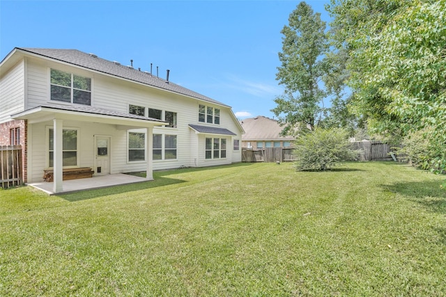 rear view of house with a yard and a patio