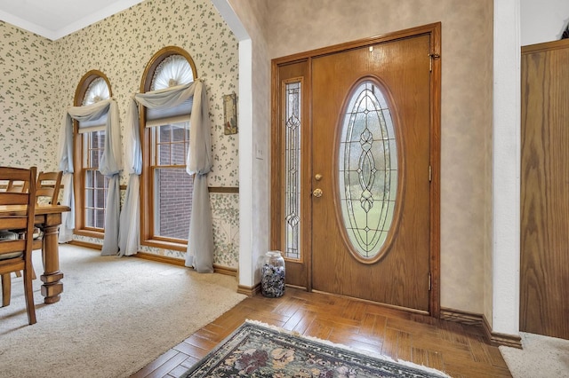 entryway featuring crown molding and light parquet floors