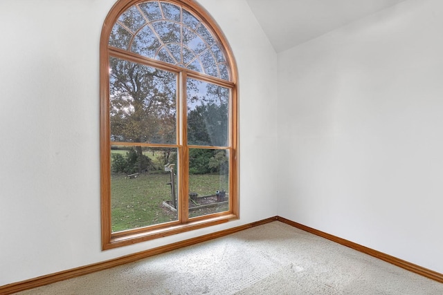 unfurnished room featuring carpet floors and vaulted ceiling