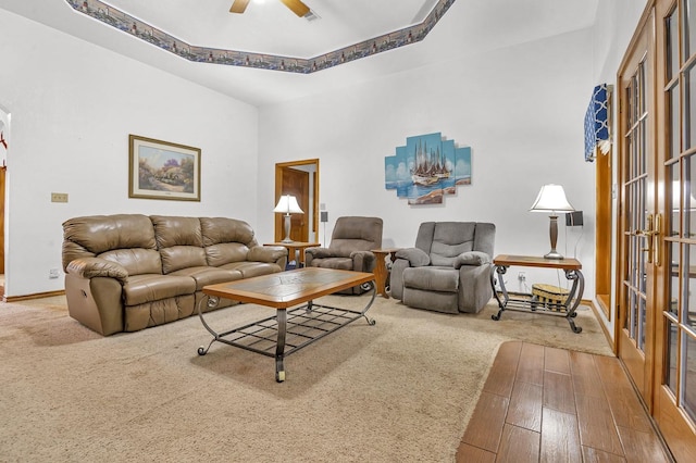 living room featuring a tray ceiling, ceiling fan, and hardwood / wood-style floors