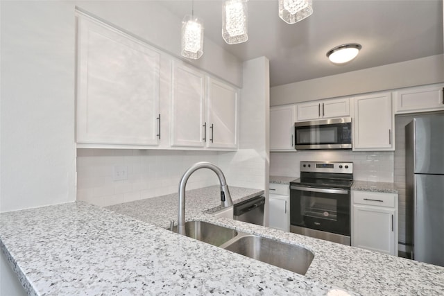 kitchen with light stone countertops, decorative backsplash, white cabinets, and stainless steel appliances