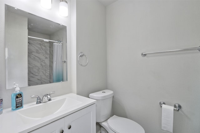 bathroom with walk in shower, vanity, and toilet