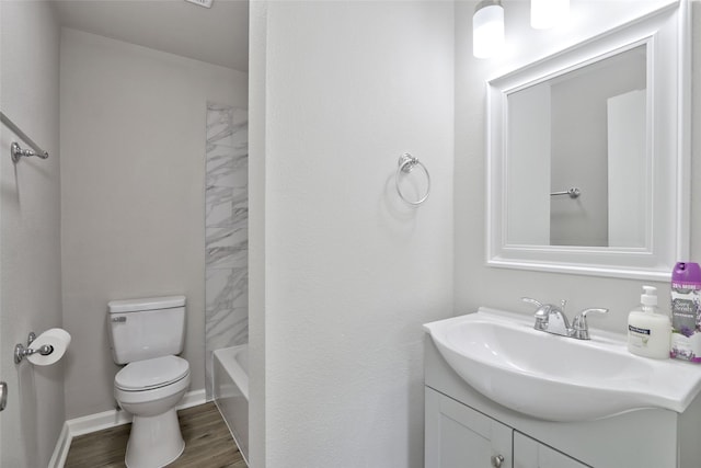 full bathroom featuring vanity, hardwood / wood-style flooring, toilet, and tiled shower / bath combo