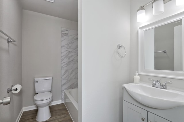 full bathroom featuring tiled shower / bath, hardwood / wood-style floors, vanity, and toilet