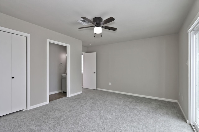 unfurnished bedroom with ceiling fan, a closet, carpet, and ensuite bathroom