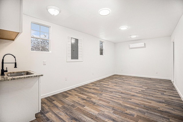 interior space featuring electric panel, dark hardwood / wood-style floors, a wall mounted AC, and sink