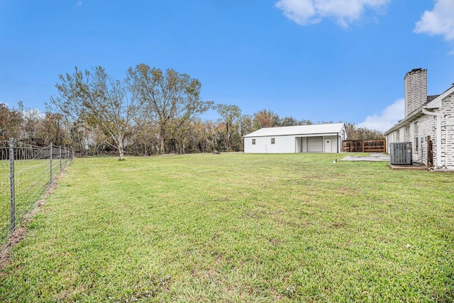 view of yard with central AC, an outbuilding, and a garage