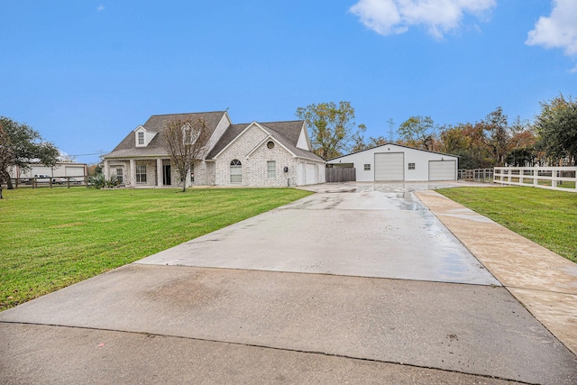 view of front of property with an outbuilding, a garage, and a front lawn