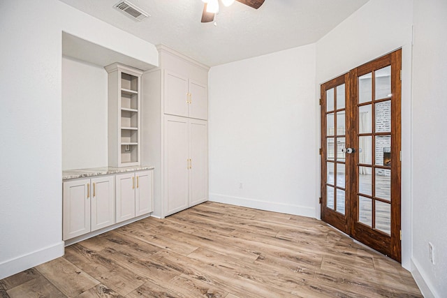 spare room with ceiling fan, light wood-type flooring, a textured ceiling, and french doors