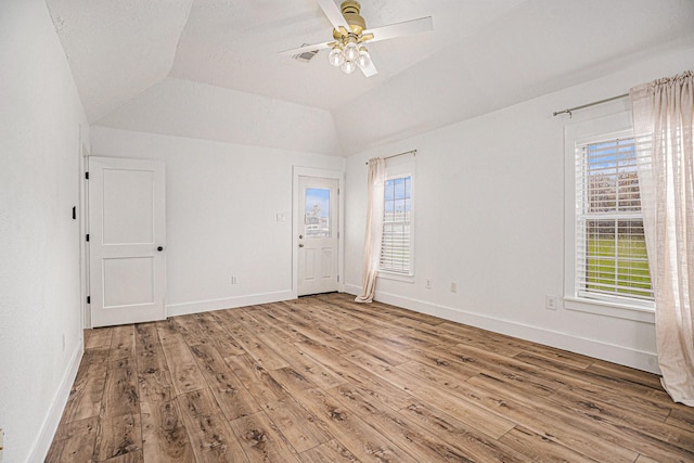 spare room featuring ceiling fan, vaulted ceiling, and light wood-type flooring