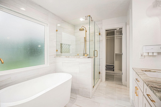 bathroom featuring vanity, tile walls, and plus walk in shower