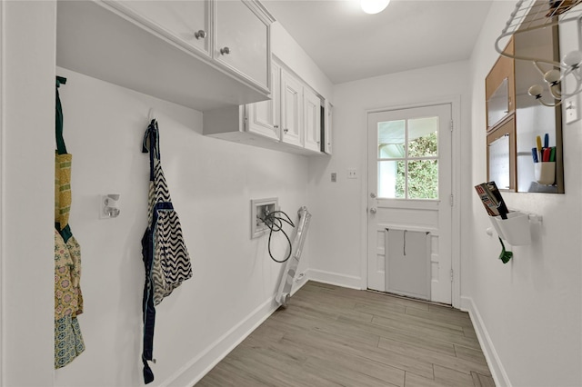 clothes washing area featuring cabinets, washer hookup, and light wood-type flooring