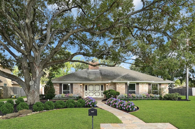 single story home featuring a front lawn