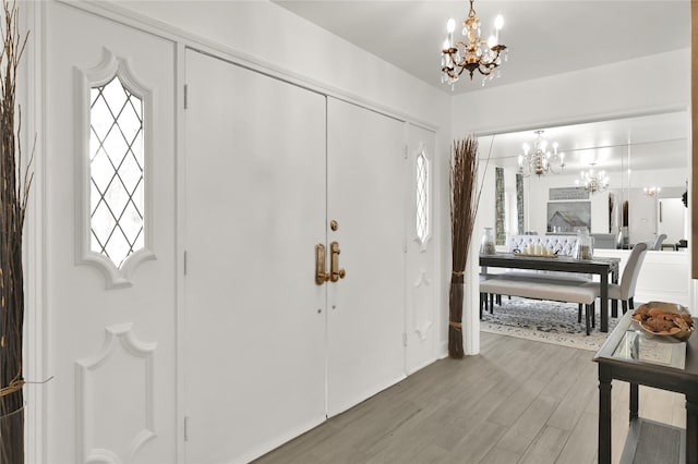 foyer with hardwood / wood-style floors and a notable chandelier