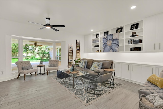 living room featuring ceiling fan, a healthy amount of sunlight, and light wood-type flooring