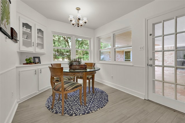 dining space featuring light hardwood / wood-style floors and a notable chandelier