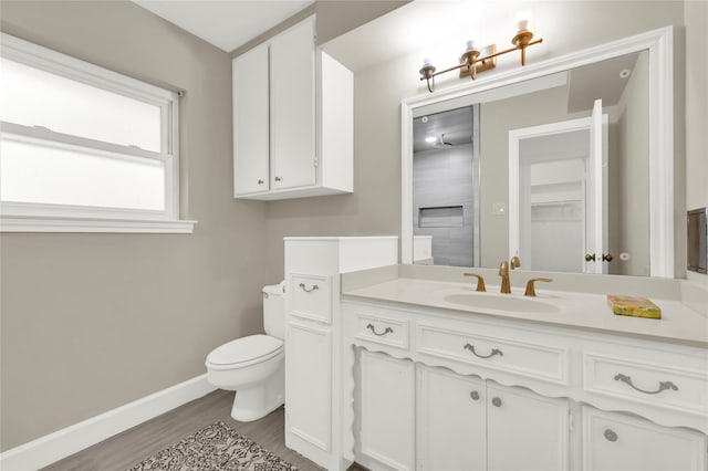 bathroom with wood-type flooring, vanity, and toilet