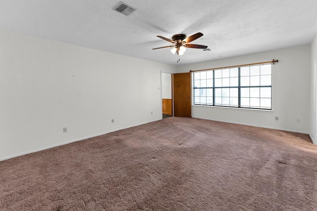 carpeted spare room featuring ceiling fan and a textured ceiling