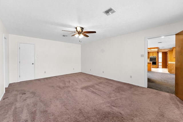 unfurnished room with carpet flooring, a textured ceiling, and ceiling fan