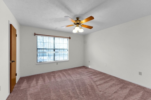 empty room featuring ceiling fan, carpet, and a textured ceiling