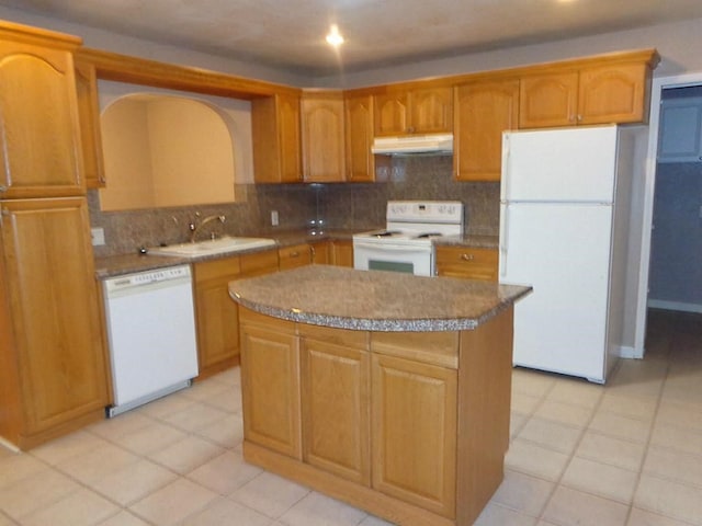 kitchen with tasteful backsplash, white appliances, sink, light tile patterned floors, and a center island