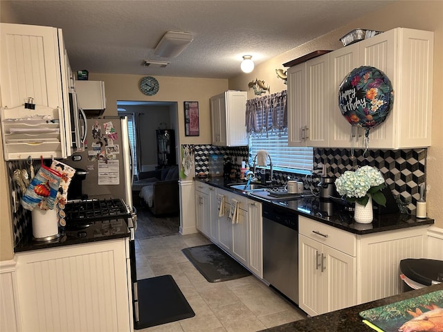 kitchen with a textured ceiling, white cabinetry, sink, and appliances with stainless steel finishes