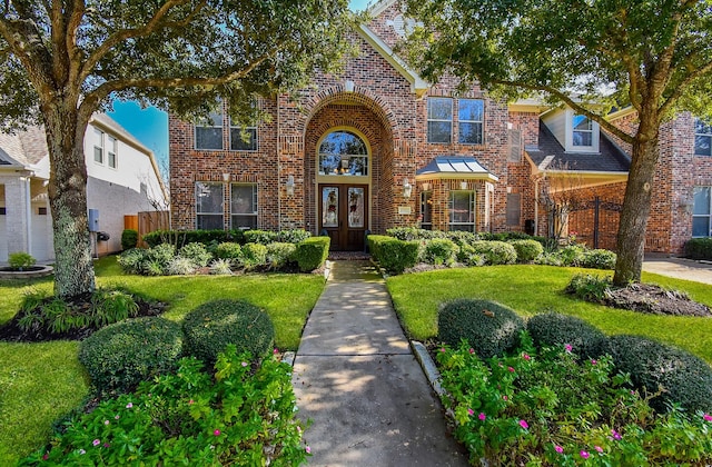 tudor-style house with a front lawn and french doors